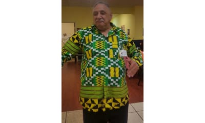 Resident wearing a colorful African print shirt in the activity room