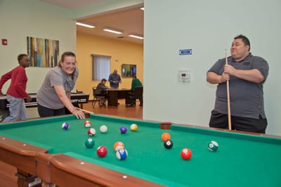 Residents enjoying a game of pool in a common area