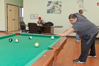 Residents playing pool in an activity room