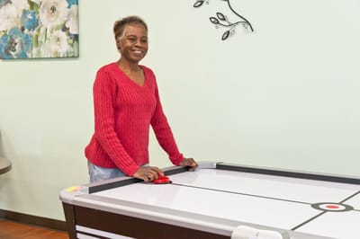 Resident enjoying a game at an air hockey table