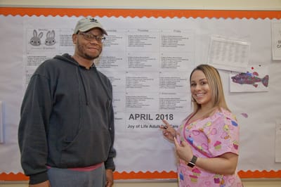 Staff member with resident pointing at a schedule