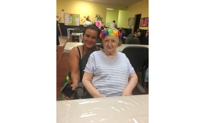 Staff and resident smiling together in a common area