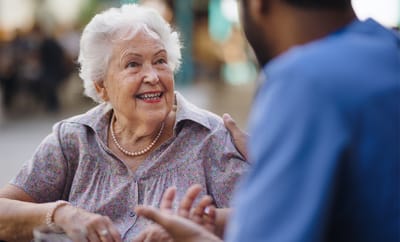 A senior woman smiling during a conversation outdoors