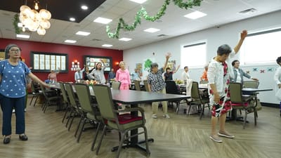 Residents participating in a light exercise class in a common area
