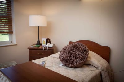 Cozy resident room with a bed and lamp
