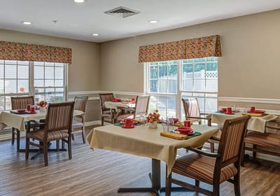 Dining room with tables and chairs set for meal service