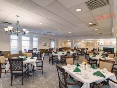 Dining room set up for a meal with tables and chairs
