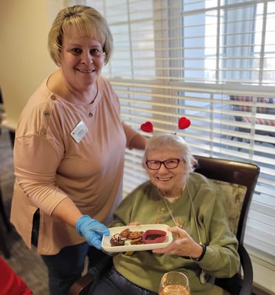 Staff member serving dessert to a resident