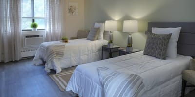 Private resident room with two beds and bedside tables