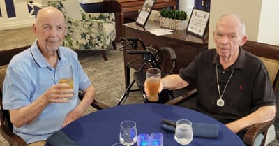 Two male residents enjoying drinks in a common area