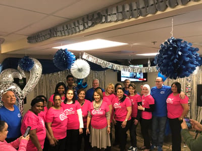 Staff and residents celebrating in a decorated common area