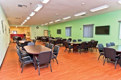 Brightly lit common area with tables and chairs