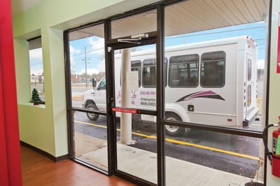 View of facility entrance with transportation vehicle outside