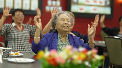 Residents enjoying a group activity with raised hands
