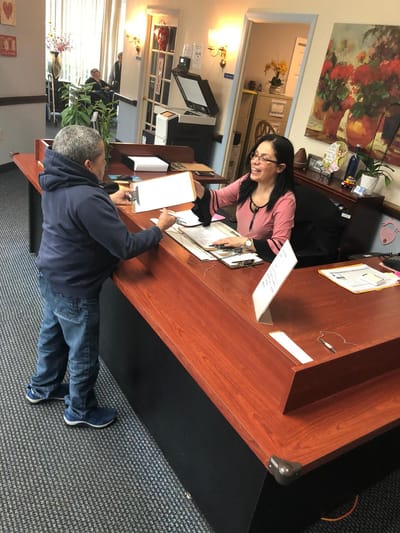 Reception area with a staff member assisting a resident