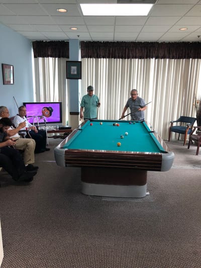 Residents enjoying a game of pool in the activity room