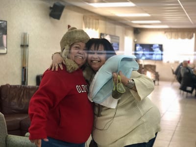 Two residents smiling and posing in a common area