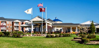 Exterior view of Applewood Village with flags and landscaping