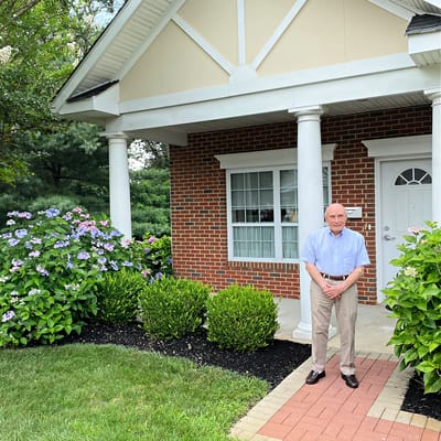 Smiling resident standing in front of a facility entrance