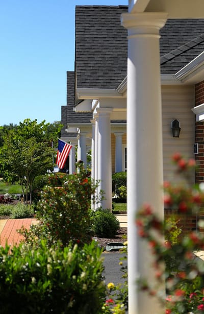 Pathway with gardens and American flag in a senior living community