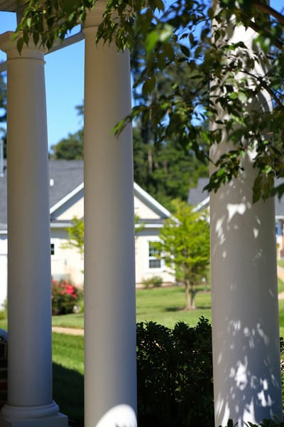 View through white columns towards facility grounds