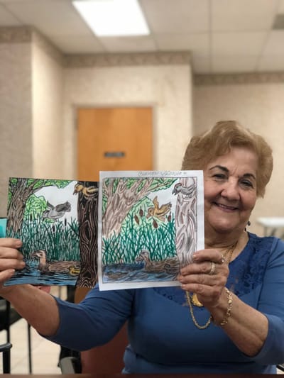 Resident proudly showing her colored artwork