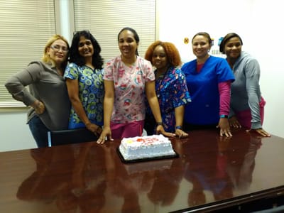 Staff members celebrating with a cake in a communal room