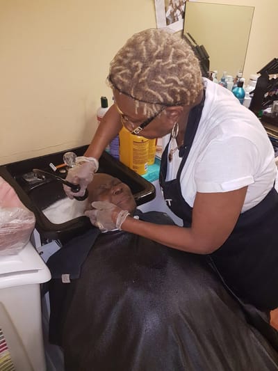 Stylist giving a hair treatment to a resident in a salon