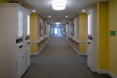 Hallway with artwork and light fixtures in a senior care facility