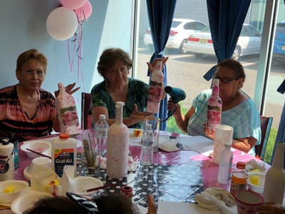 Residents engaging in a craft activity at a dining table