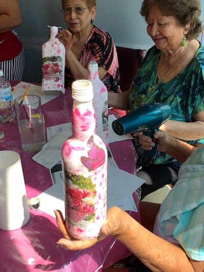 Residents engaging in a crafting activity with painted bottles