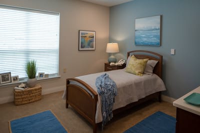 Cozy bedroom with a bed, artwork, and window