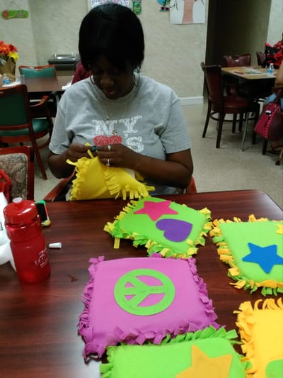 Resident engaging in a craft activity with colorful materials