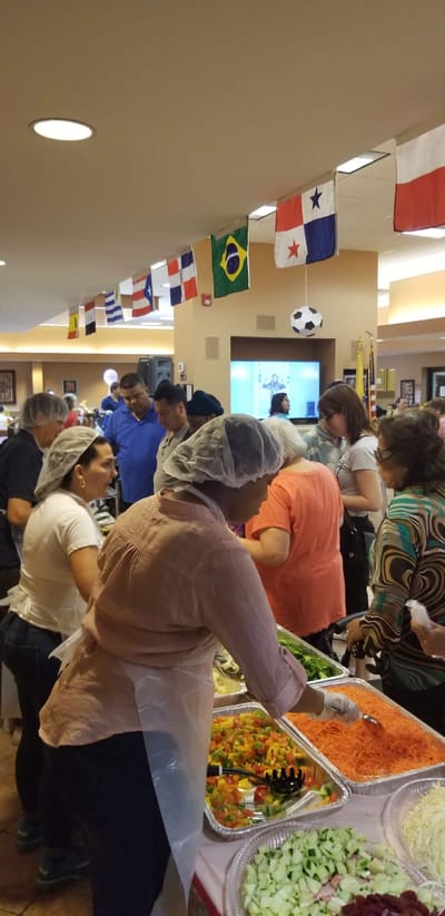 Residents and staff enjoying a food event indoors