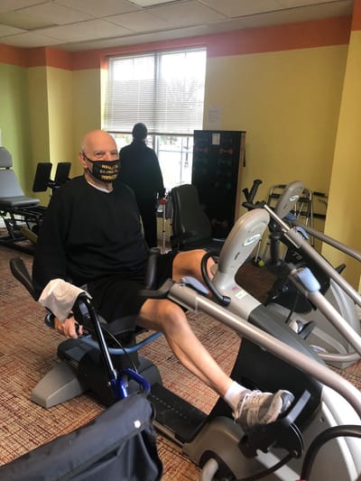 Resident exercising on a fitness machine in the gym