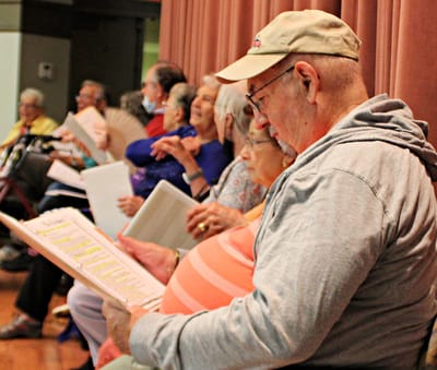 Residents participating in a group activity reading music sheets