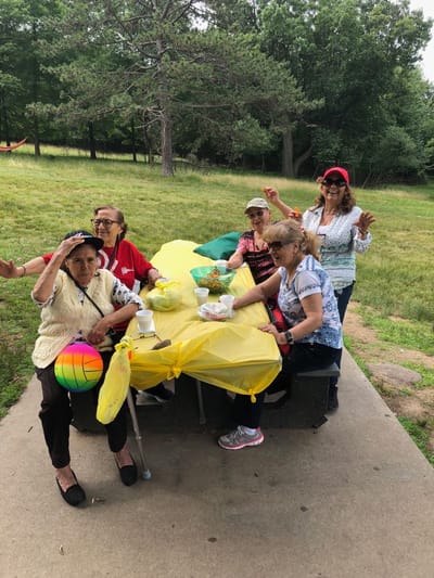 Residents enjoying a picnic outdoors in a garden setting