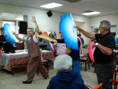 Residents participating in an indoor activity with colorful fans