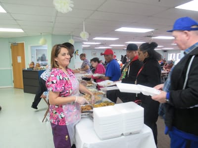 Staff serving food to residents in a dining area