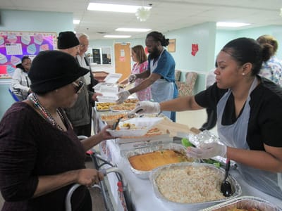 Residents enjoying a meal with staff assistance