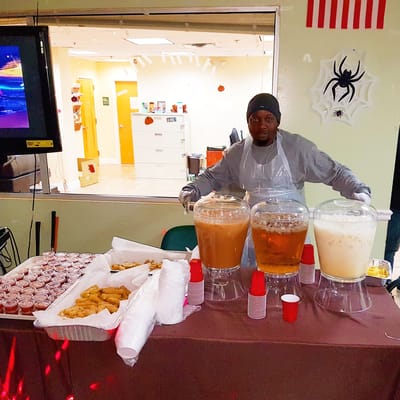 Staff serving food at a festive event in the facility