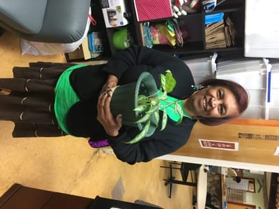 A resident proudly holding a potted plant