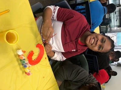 Resident painting in a colorful activity room