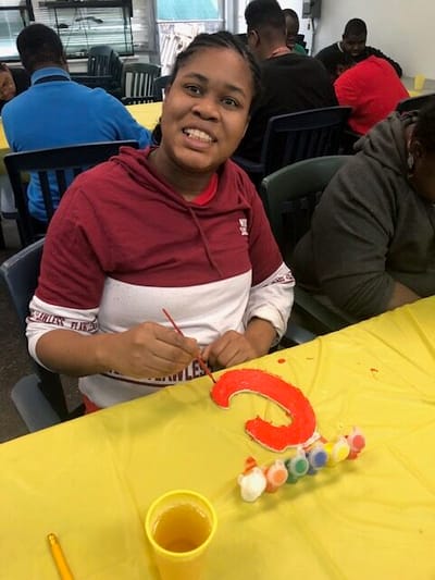 Resident painting during an indoor activity session