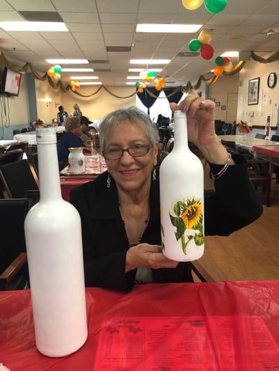 Resident engaged in a creative activity with painted bottles