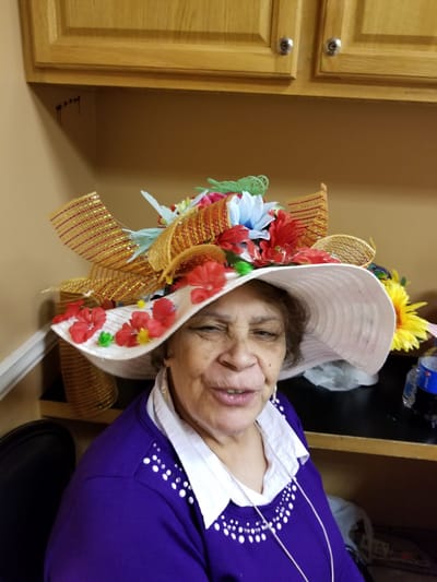 Resident wearing a decorative hat with flowers