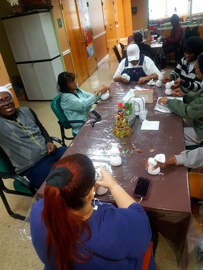 Residents engaged in a craft activity at a dining table