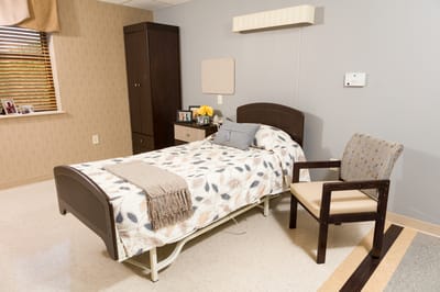 Private resident room with a bed and chair