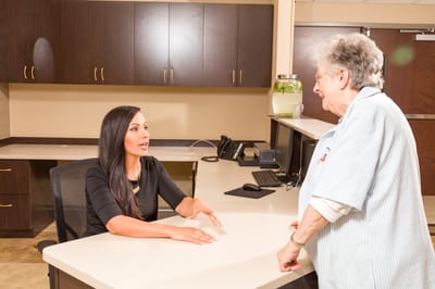 Staff member discussing with a resident at the reception desk