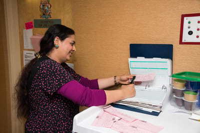 Staff member organizing paperwork in the facility office